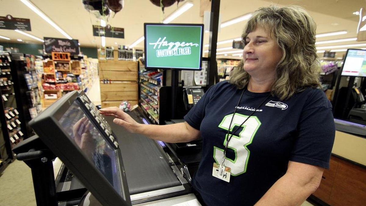 Gig Harbor Haggen store checker and 35-year employee Terri Carley logs in to her check stand on Friday morning. Carley is part of a small group that has worked at the store for more than 20 years.