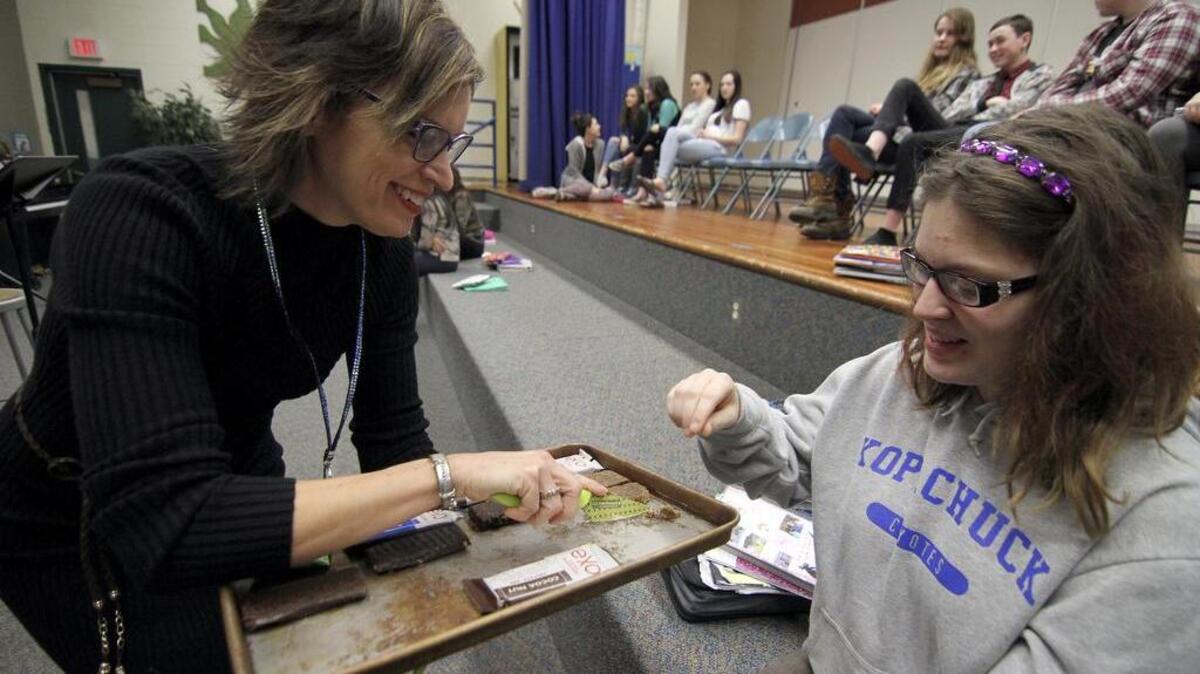 Kopachuck Middle School teacher Kathy Johnson watches as homeroom period student Monique Jaber, 15, samples a peanut butter and jelly breakfast bar that contains cricket flour. “I can’t taste the crickets. It’s really good,” Jaber said.