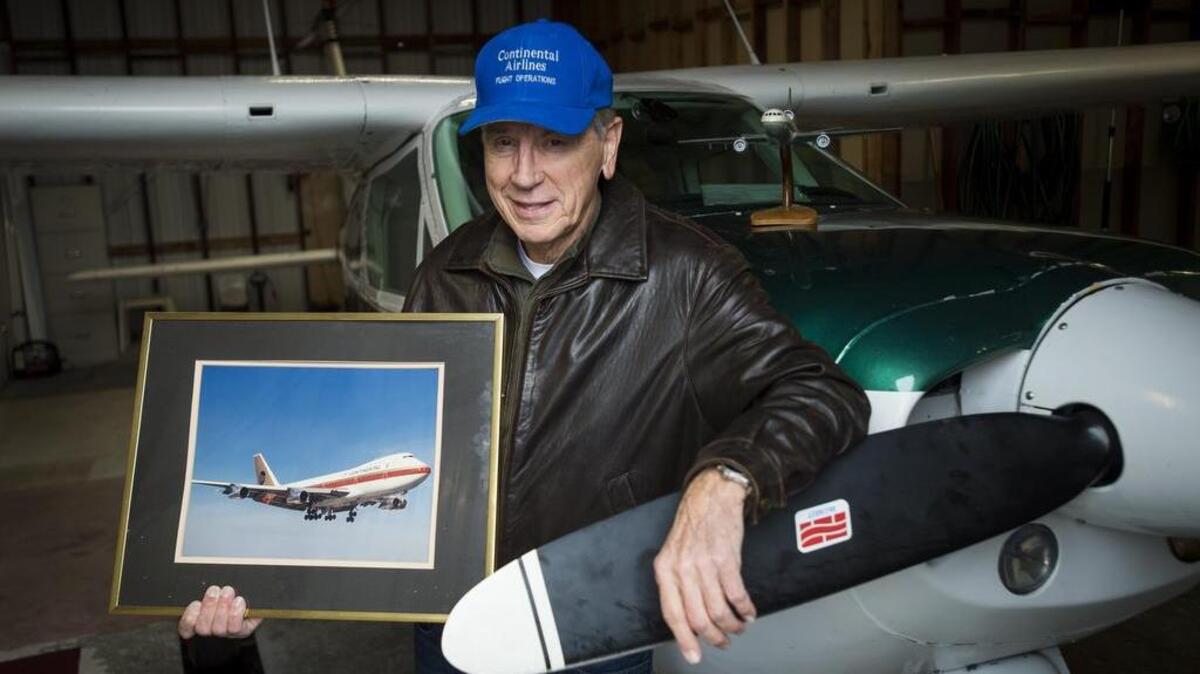 Carl Domschke, pictured at the Tacoma Narrows Airport in Gig Harbor, holds a photograph of a Boeing 747, one of the planes he flew while working for Continental Airlines.