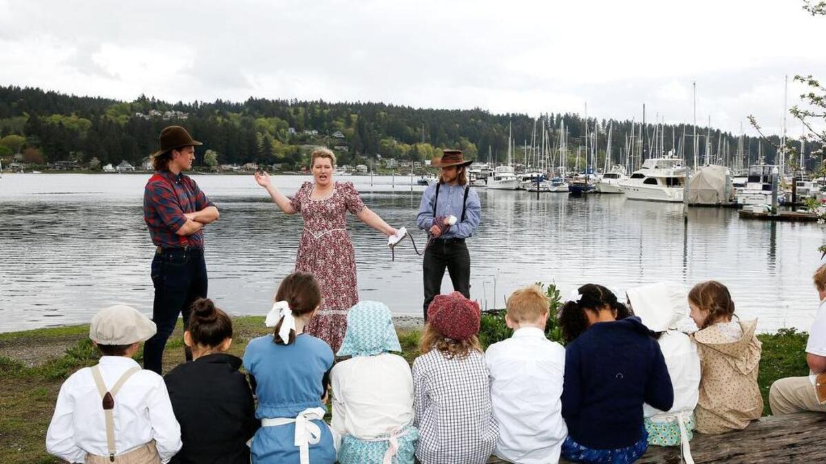 Students from Gig Harbor Academy listen to a reenactment of the life of a Blake Island smuggler during a presentation April 13.