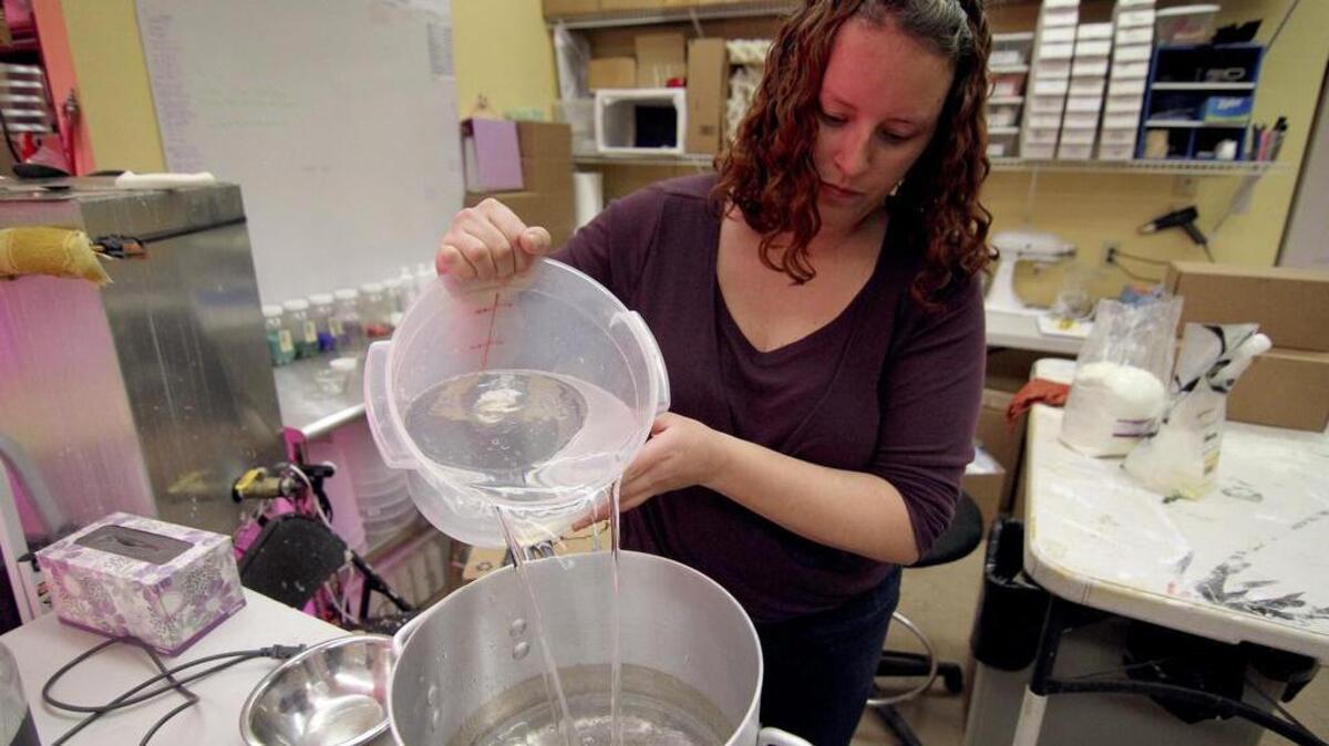 Jess Hogan pours water into a cooking pot in preparation for making a new batch of goat’s milk lotion. Jess and her husband, Scott, own Artondale Farm and will be selling their line of beauty products at the new Main & Vine store.
