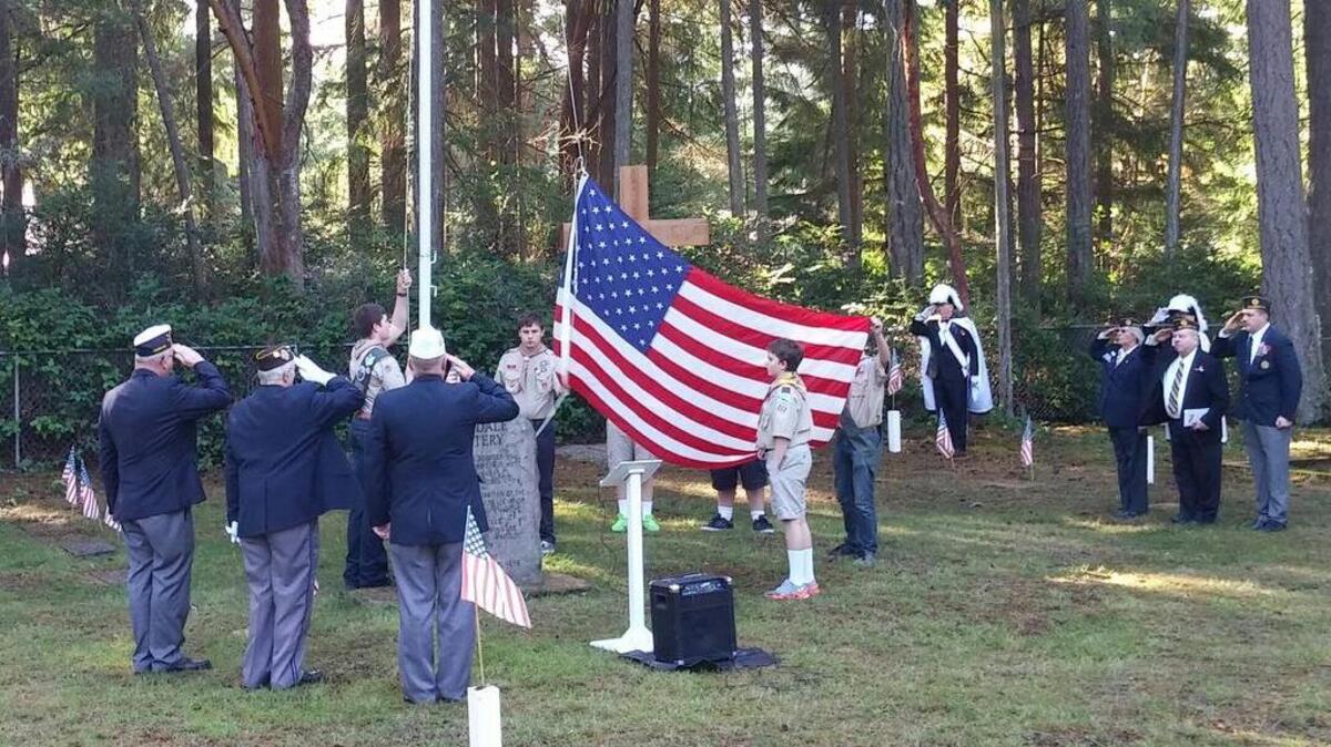 Boy Scouts from Troop 212 help raise the flag Wednesday morning during the Veterans Day ceremony at Artondale Cemetery.