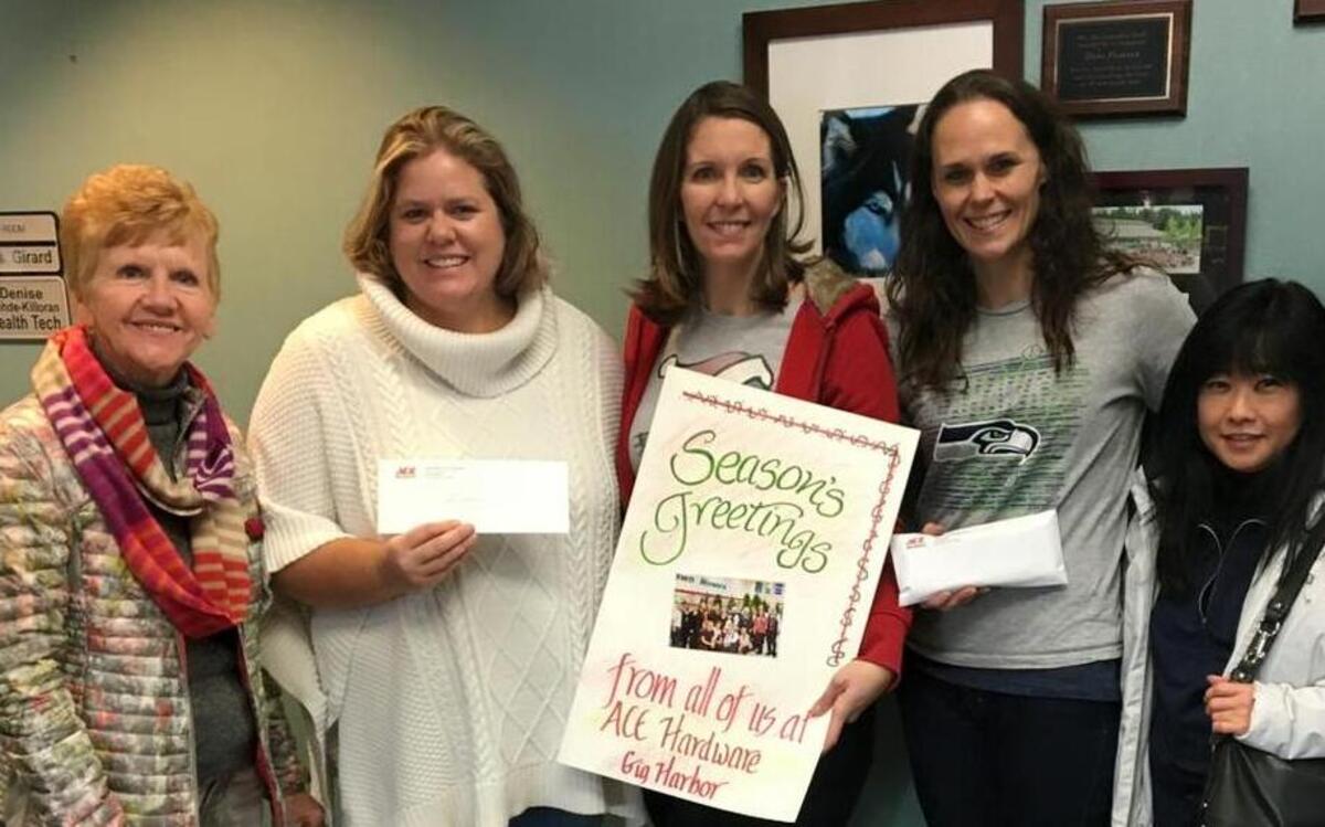 Gig Harbor Ace Hardware donated $2,700 to Vaughn Elementary. Business owners Maggie Garber, left, and Lisa Mikami, far right, pose with teachers at the school on Dec. 15.