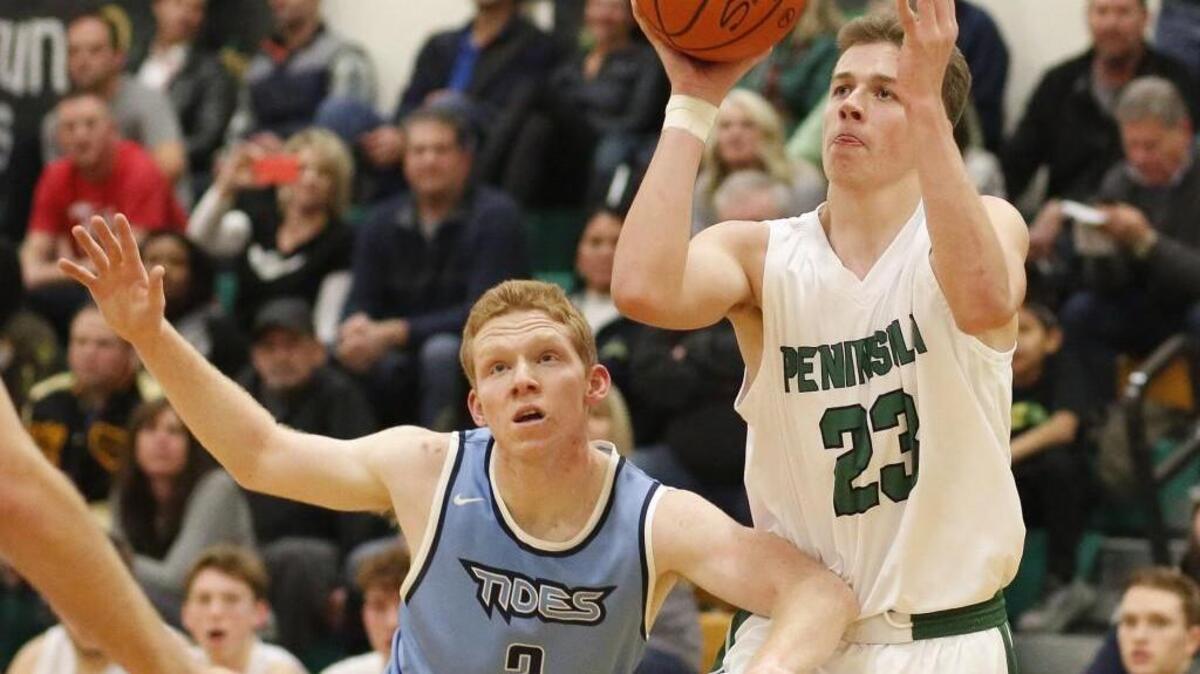 Peninsula’s Nate Thompson (23) shoots around Gig Harbor’s Collin Brooks (3) in the third quarter of Friday’s game.