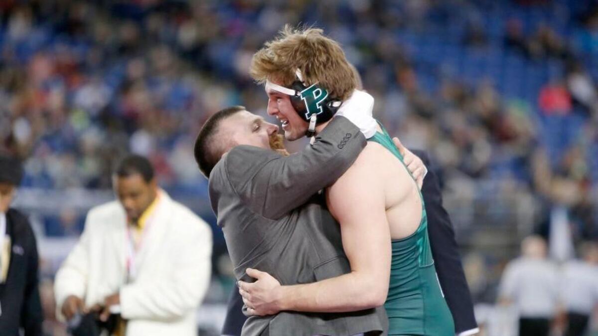 Peninsula High School senior Chance Stolz celebrates with assistant coach Gary Griffin after he pinned Kennedy Catholic’s Bowen McConville on Saturday night in the Class 3A 195-pound state championship match to win the state title.
