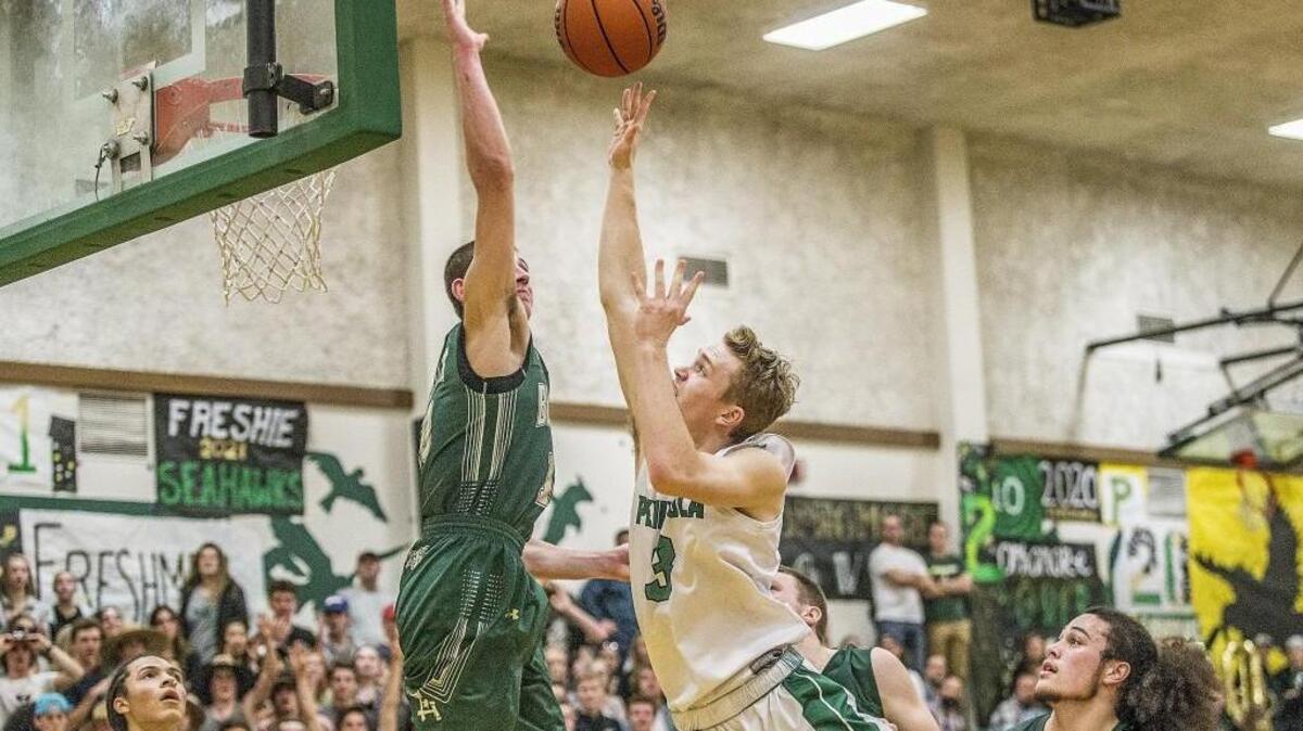 Timberline guard Erik Stevenson (10) blocks a shot by Peninsula guard Sam Miller (3) in the fourth quarter.