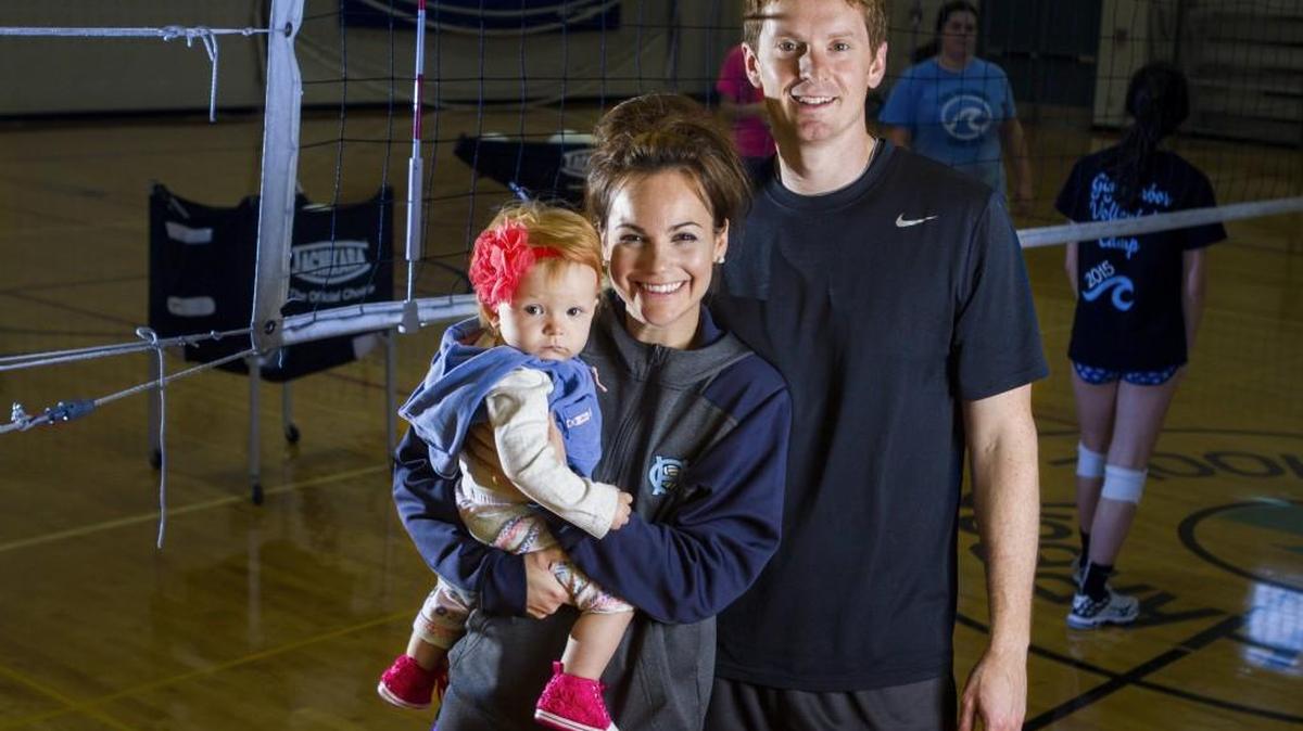 Gig Harbor High volleyball coaches Melissa and Slade Klein stand for a portrait with their daughter, Everlyn, after practice on Friday. The Kleins have coached volleyball together for eight years.