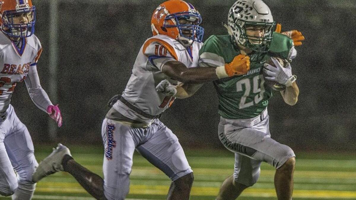 Seahawks Michael Foreman (29) is tackled by the Vikings' Chaun Hollins (10) during the 3A state quarterfinal football game between Peninsula High School Seahawks and Rainier Beach High School Vikings at Roy Anderson Field.