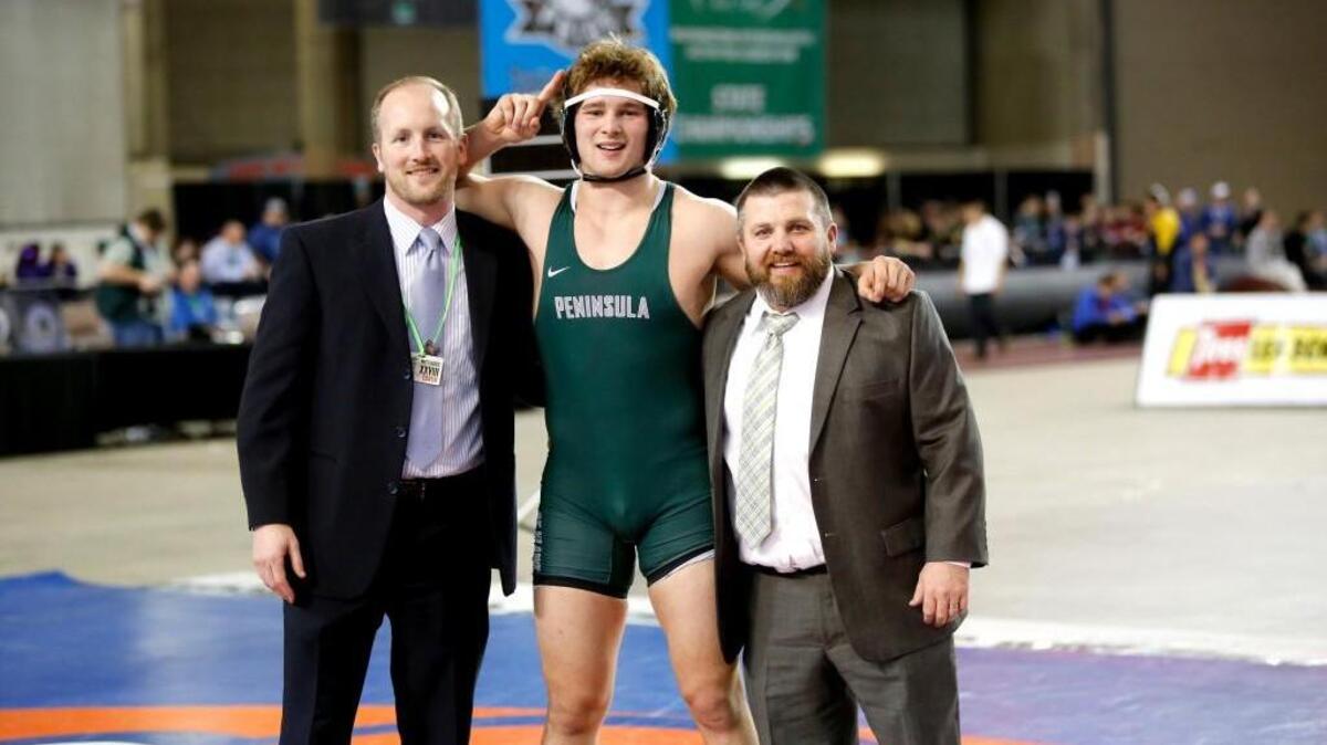 Peninsula High School senior Chance Stolz was all smiles with his coaches Mark Nickel, left and Gary Griffin after pinning Kennedy Catholic’s Bowen McConville in the Class 3A 195-pound state championship match to win the state title. Stolz will continue his wrestling career next year at Arizona State University.