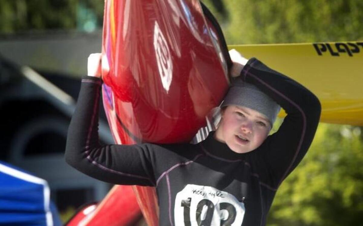 Rylee Price carries her kayak to the water during the fourth Annual Gig Harbor Paddlers Cup at Skansie Brothers Park in April of 2015.