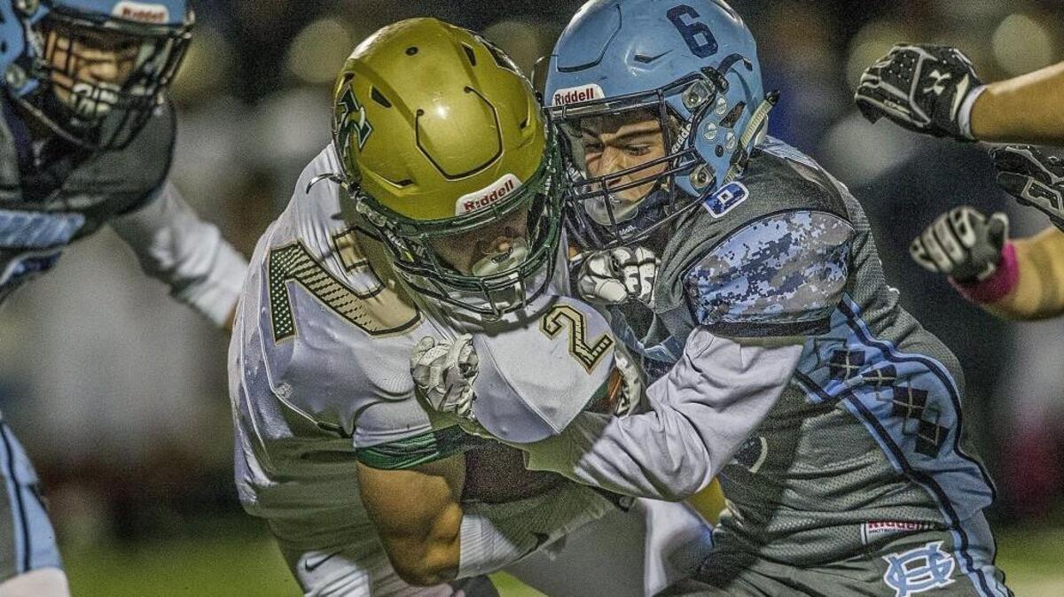 Blazers. Michael Barnes (2) is wrestled to the turf by the Tides' Ryan King (6).