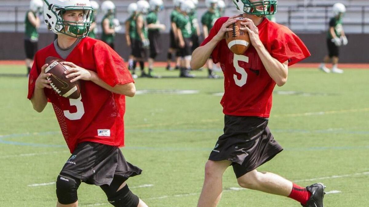 Burke Griffin, left, and Cooper Sims, right, compete in drills during football practice at Peninsula High School on Thursday.