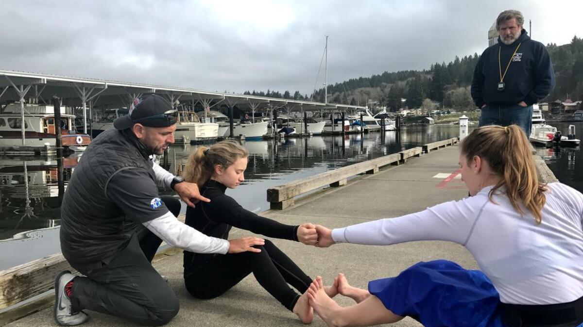 Zsolt Szadovski, Team USA coach for the 2017 Sprint Canoe Junior World Championships, left, works with members of the Gig Harbor Canoe and Kayak Racing Team last week while coach Alan Anderson, right, looks on.