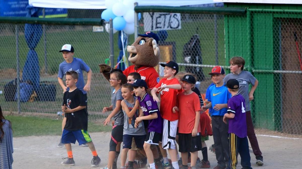 Kids laugh and smile with the Tacoma Rainiers' mascot, Rhubarb, at the Gig Harbor Little League fields.