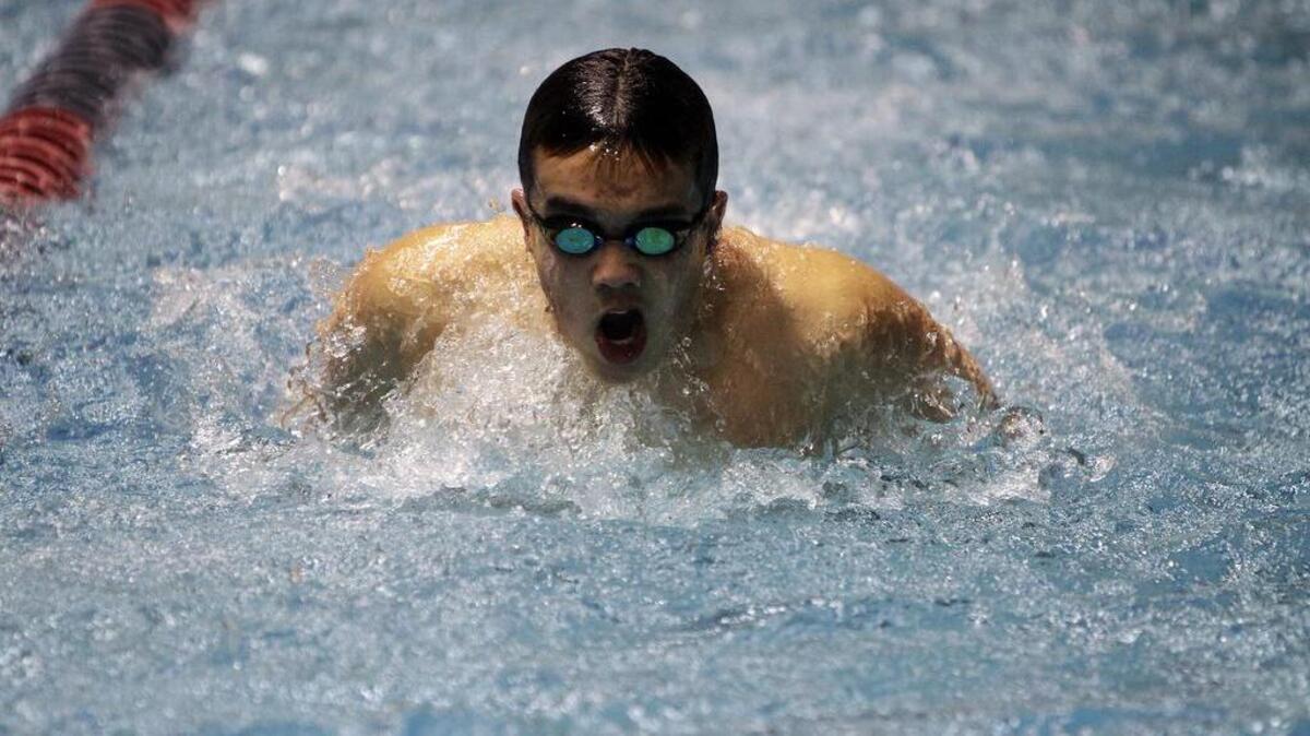 Clay Curtis of the Gig Harbor High swim team takes laps at the Class 4A state swimming and diving championship prelims earlier this year. Many of the Gig Harbor High swimmers practice for club swimming in Tacoma when they are not swimming for their high school team.