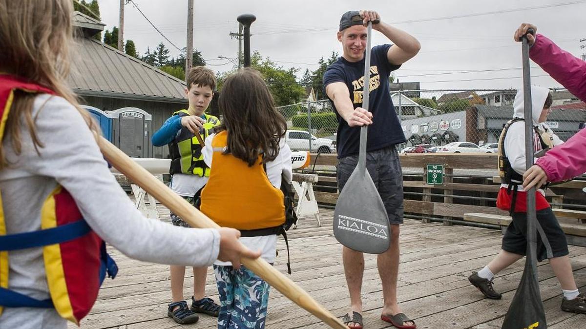 Ryan Mechini teaches students how to hold their oars before going out on an outrigger canoe last week.