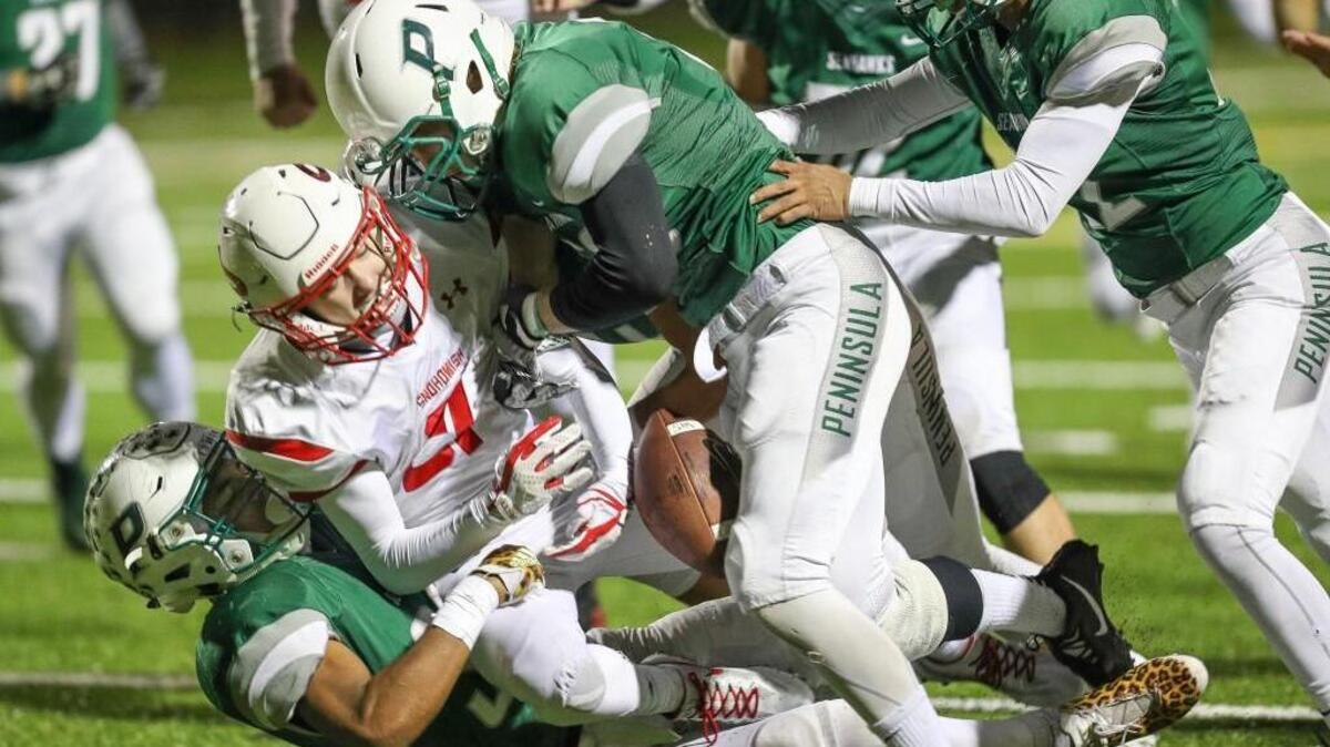 Peninsula's Braeden Potter Potter and No. 53 Isaac Casey strip the ball from Panthers' running back Keegan Stich.