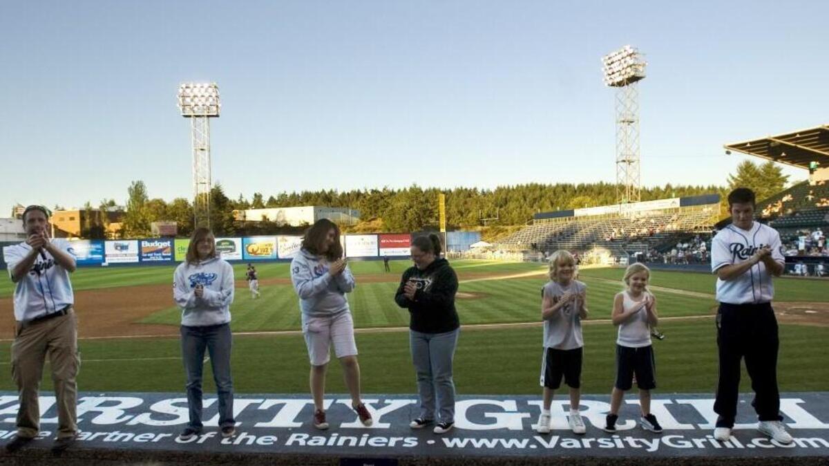 Rainiers employees and fans enjoy a dance on top of the dugout in 2007. The Tacoma Rainiers have been a steady employer for local high school students looking for summer work.