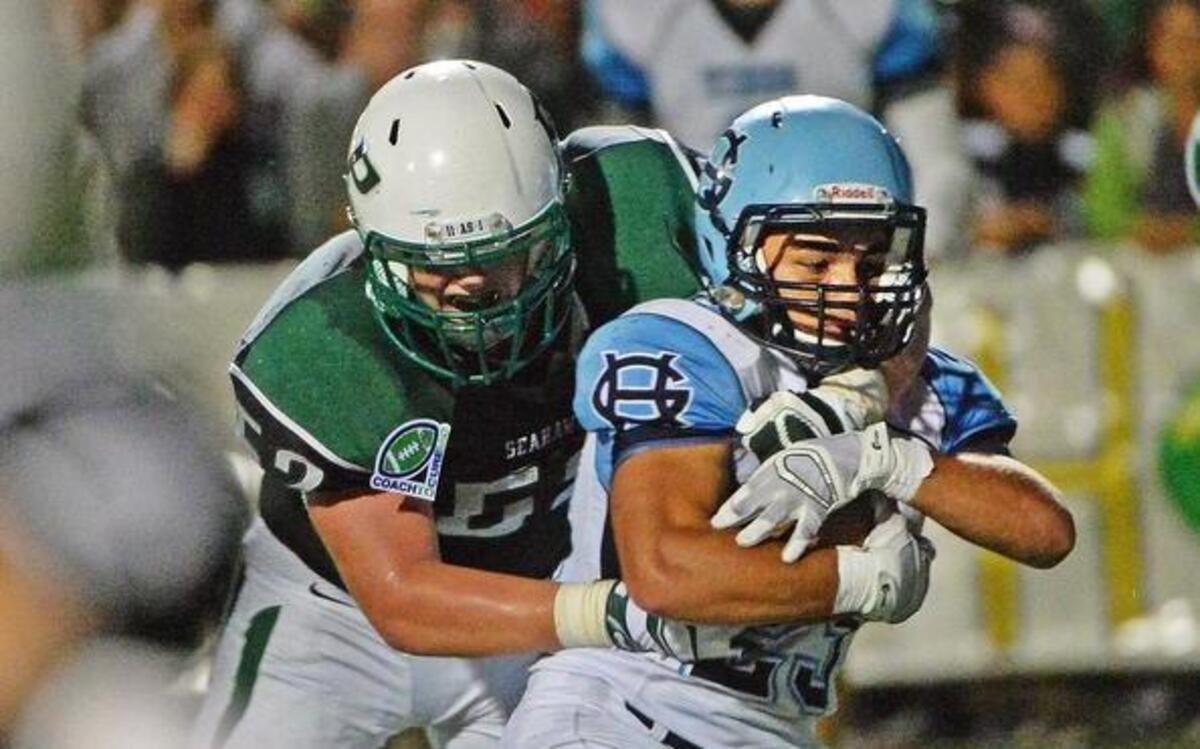 
Gig Harbor's Adrian Valona is tackled in the 2014 Fish Bowl, which the Tides won, 30-29. Gig Harbor holds the edge in the all-time series, 20-16 over Peninsula. 
