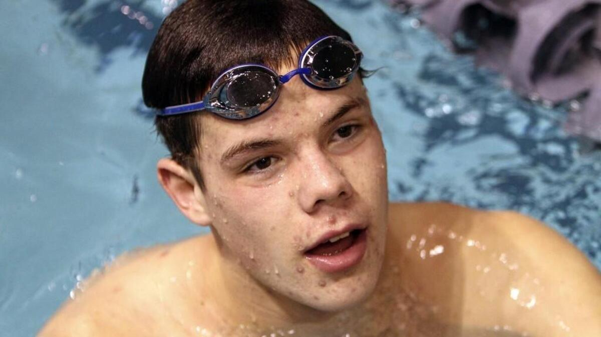 Tides swimmer Ryan Grady listens to catch Diana Litsch after warm ups Friday evening at the King County Aquatic Center.