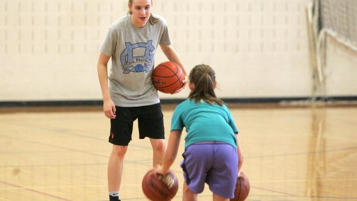 Gig Harbor’s Brynna Maxwell, fresh off a huge season, helps campers with their dribbling skills in a summer camp last week.