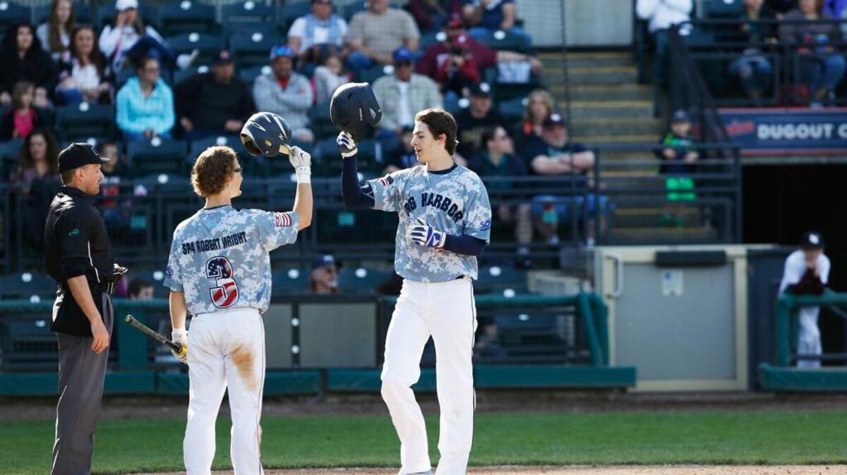 Gig Harbor senior Michael Toglia, a UCLA signee, hit a home run in the top of the 7th at Cheney Stadium against South Kitsap High School on Saturday. Teammate Cameron MacIntosh congratulates him at the plate. Each player wore a special jersey with the name of a fallen soldier on it. South Kitsap defeated the Tides, 5-4.