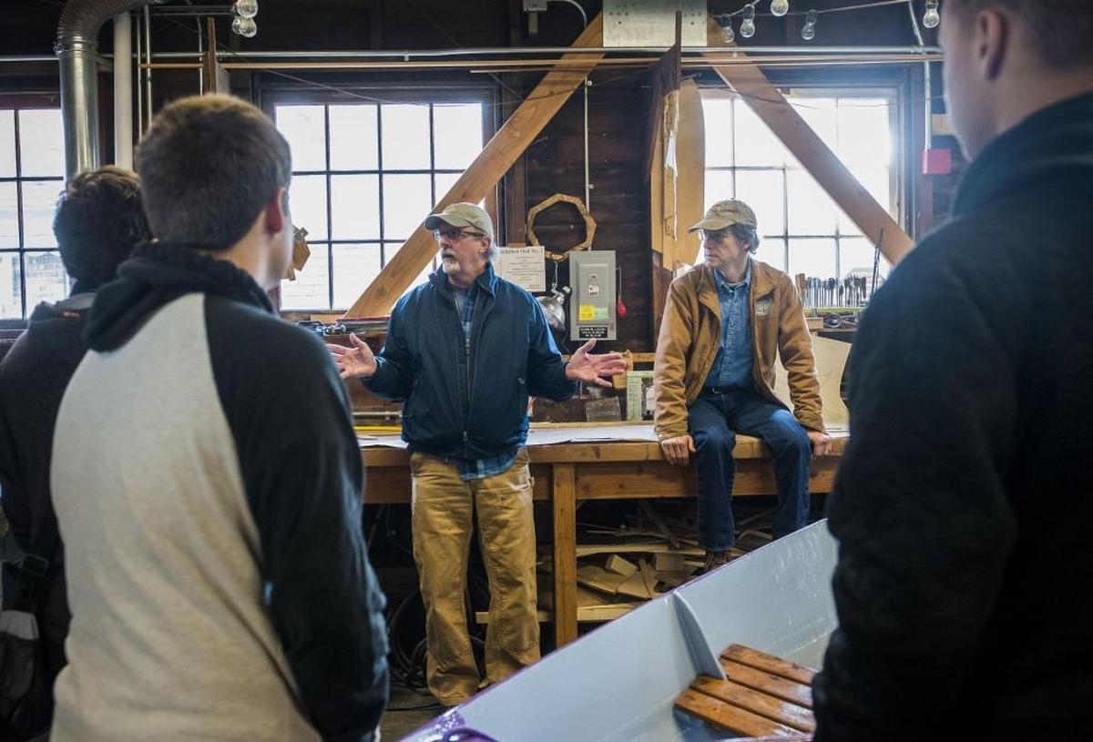 Guy Hoppen, left, and Tom Regan, right, speak to Henderson Bay High School students during a presentation at the Eddon BoatShop in Gig HarborJan. 18. The BoatShop will offer a mentorship program to selected students at the high school where they will learn how to build a boat from scratch.