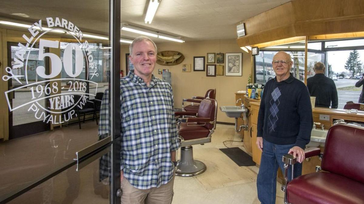 Kenny Cockle Jr. and his Valley Barber Shop in downtown Puyallup. Ken’s father, Ken Cockle Sr., right, started the barber shop 50 years ago and passed it on to his son.