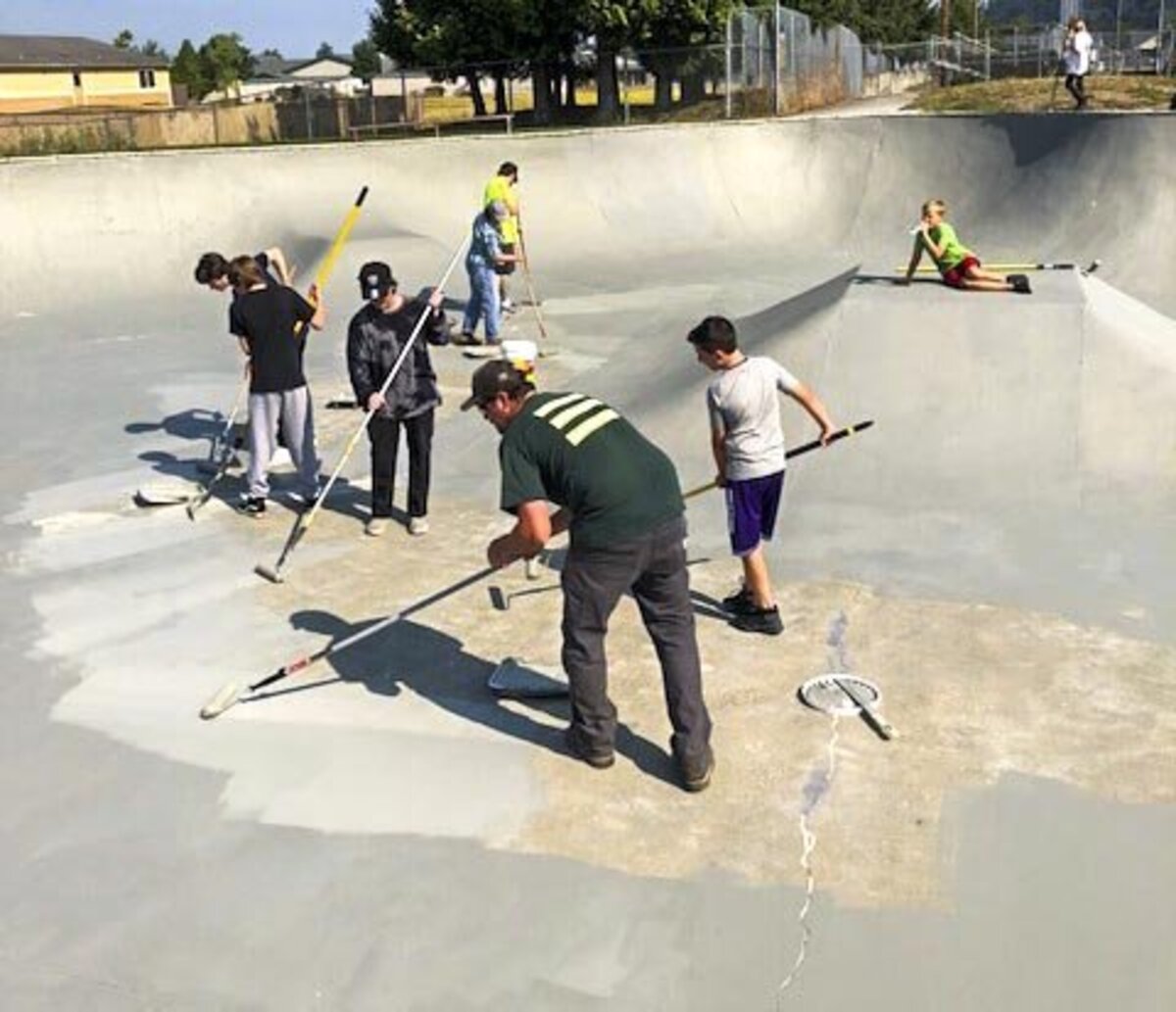 Kids and community members help repaint a newly repaired Sumner Skate Park, which has been closed since June due to damage. Aug. 18, 2018