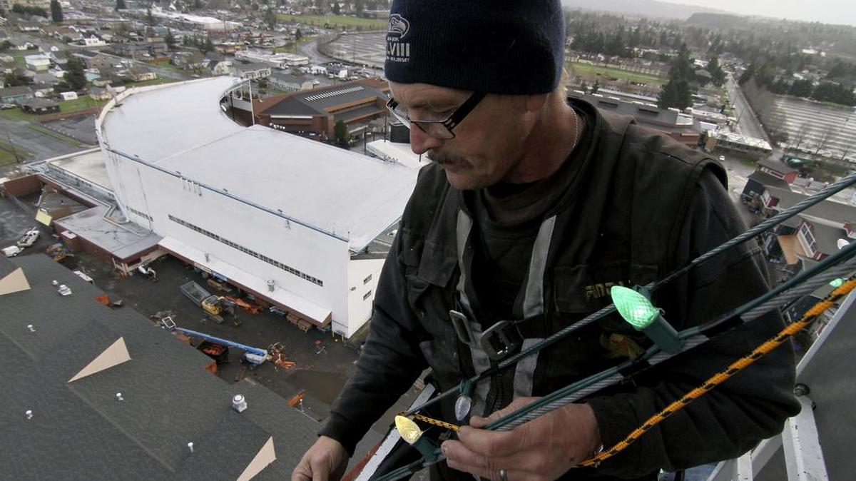Fantastic Rides manager Jack Karvia installs and checks lights last week on the 185-foot Extreme Tree at the Washington State Events Center. The Extreme Scream ride at the fairgrounds has been transformed into a large, colorful Christmas tree of multicolored lights.