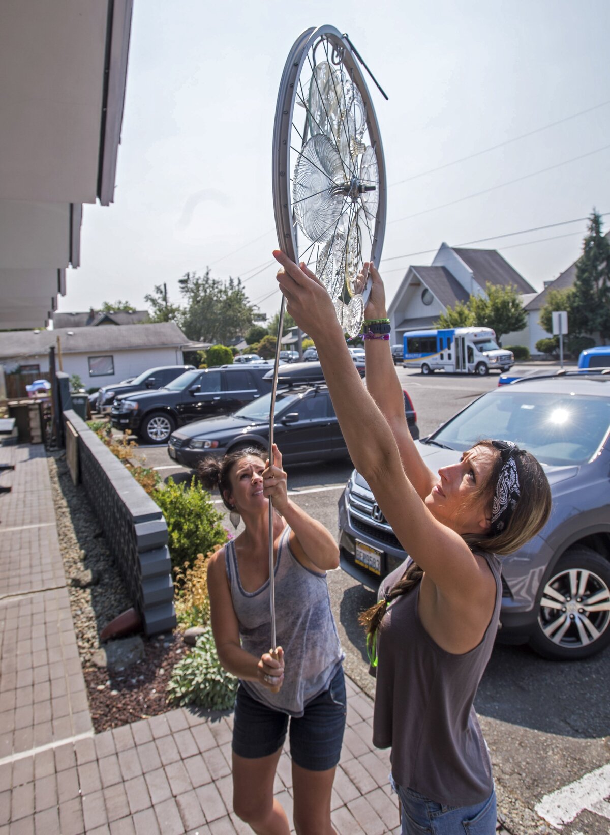 Co-owners Sierra Baker and Steph Cortez pull down a Crystal Gayle Spoke for a purchaser in their new shop, The Locals Store, in downtown Puyallup, Aug. 9.