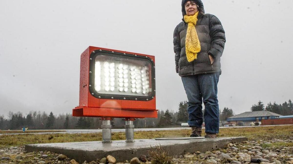 Thun Field maintenance lead Lissa Smith stands next to one of the new guiding lights installed along the Thun Field runway. The lights help distinguish the runway from roads.