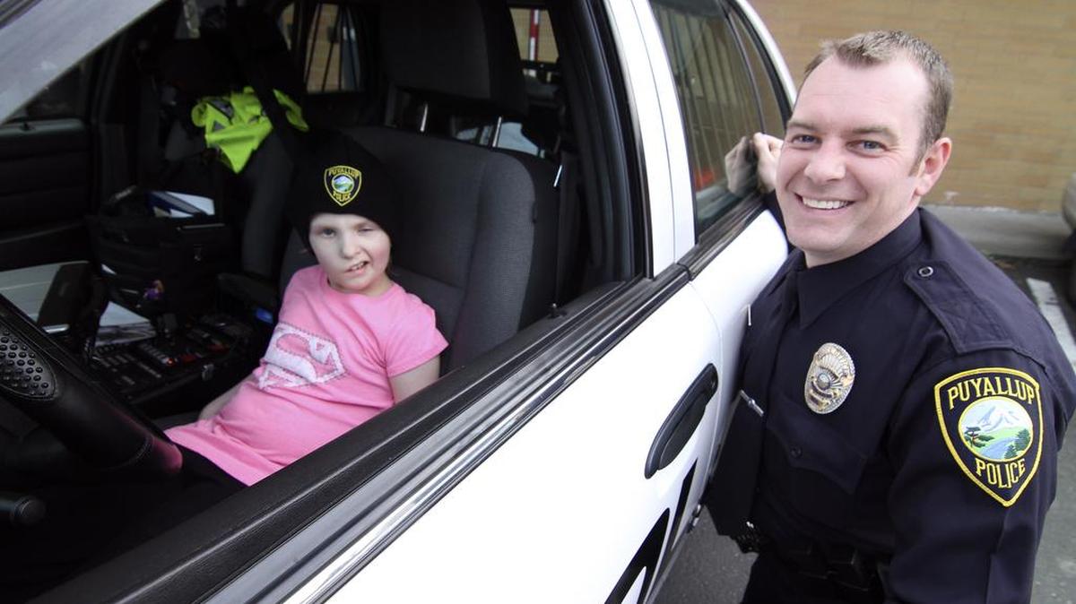 Puyallup resident and Honorary Police Chief Lillie Ann Stewart checks out the inner workings of a police patrol car last week at the Puyallup Police Department headquarters with patrol officer Mark Ketter. Stewart has been battling cancer and was given a tour and show-and-tell briefing.