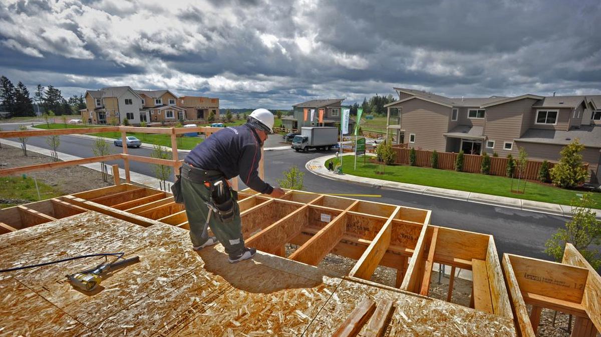 Timoteo Dias with Iron Mount Contractor LLC measures while installing the floor at Emerald Pointe housing in South Hill in 2012. Pierce County is planning for new growth in unincorporated communities as 60,000 people are expected to move in between now and 2030.