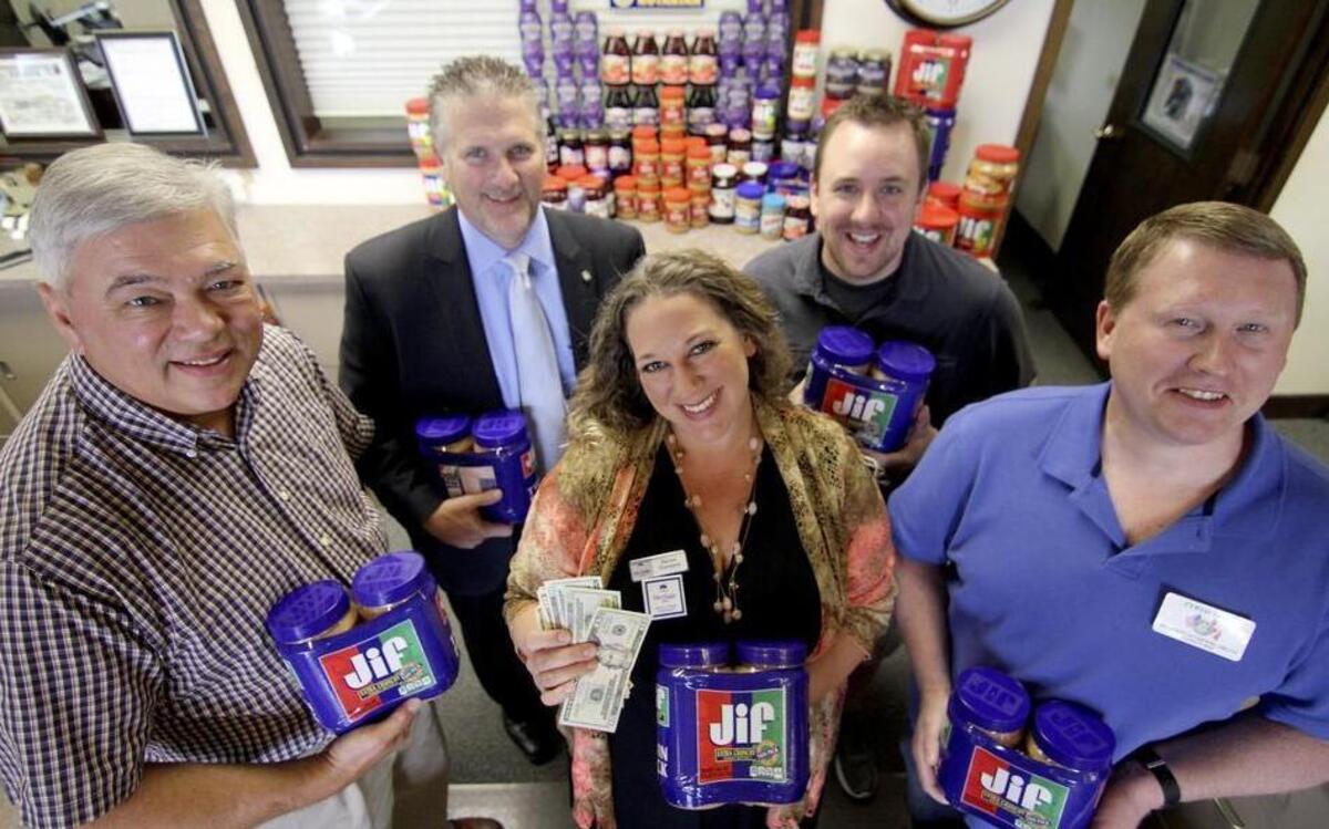 
Karissa Thompson, center, is flanked by participating Kiwanis and Rotarian members from the Puyallup community. Also participating in the food drive are members of the Puyallup Lions and Masons. The groups are collecting peanut butter and cash donations to benefit the Puyallup Food Bank.
