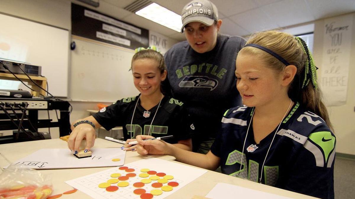 
Math Camp instructor Heidi Matson watches as Amanda Hugdahl, left, and Adele Holland work on math games last week at a summer camp held at Puyallup High School. Students utilize different math-based games during the eight-day camp to help them learn positive and negative numbers, fractions and more. 
