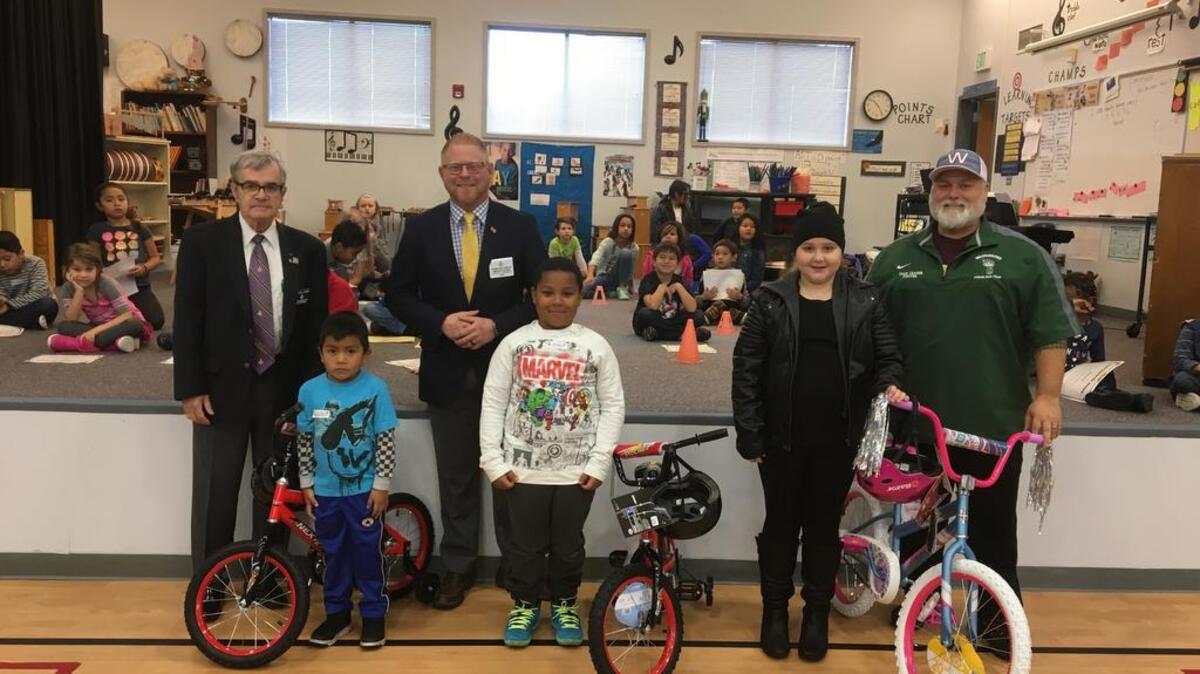 Corinthian Masonic Lodge members, from left, Fred Docker, Brian Shields and Kyle Foster stand with Elmhurst Elementary School students who received a bike as part of the Bikes for Books program..