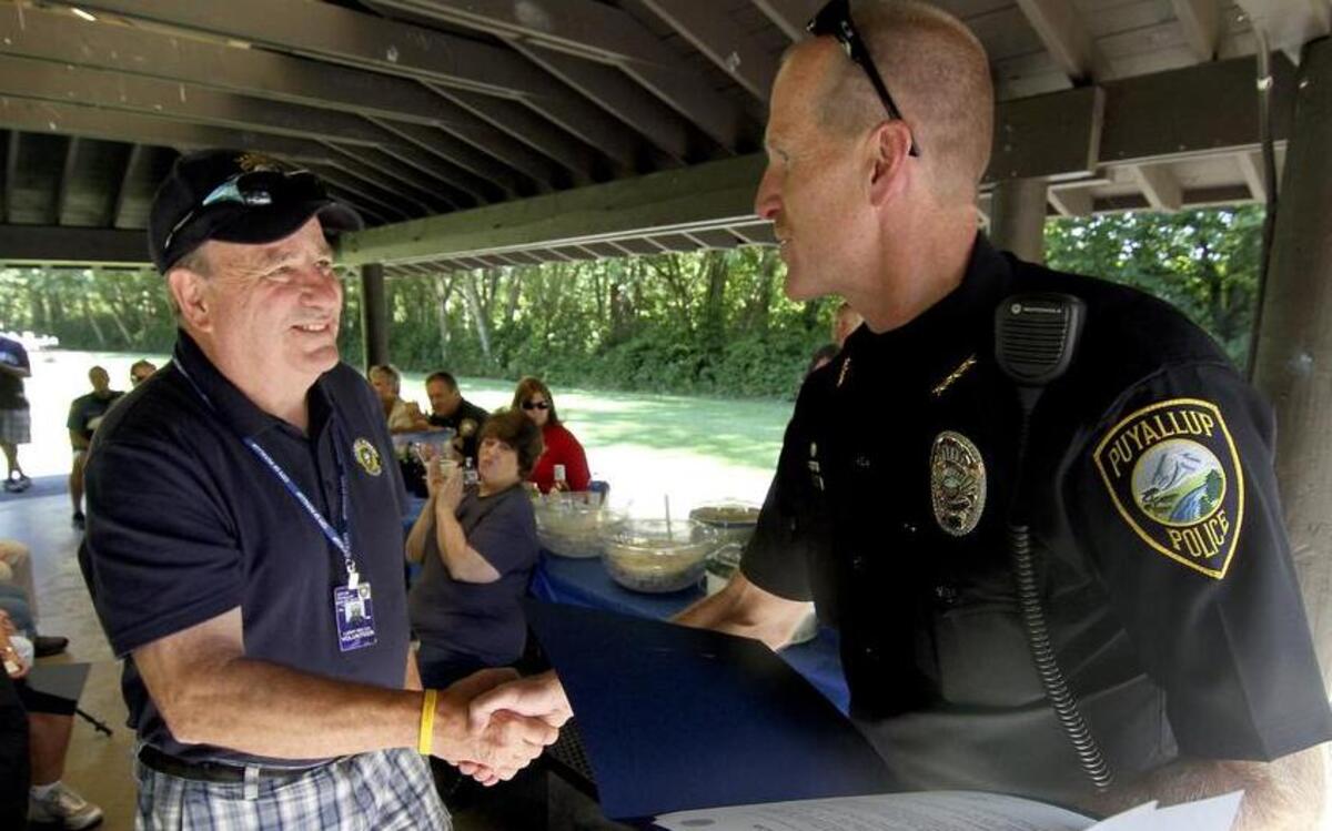 
Larry Welch shakes the hand of Puyallup Police Chief Bryan Jeter last week as he accepts the award for Volunteer of the Year for his tireless efforts in the City of Puyallup. Besides being involved in the Citizens Academy, Welch has been heavily involved in eradicating graffiti from the city’s areas parks and structures.
