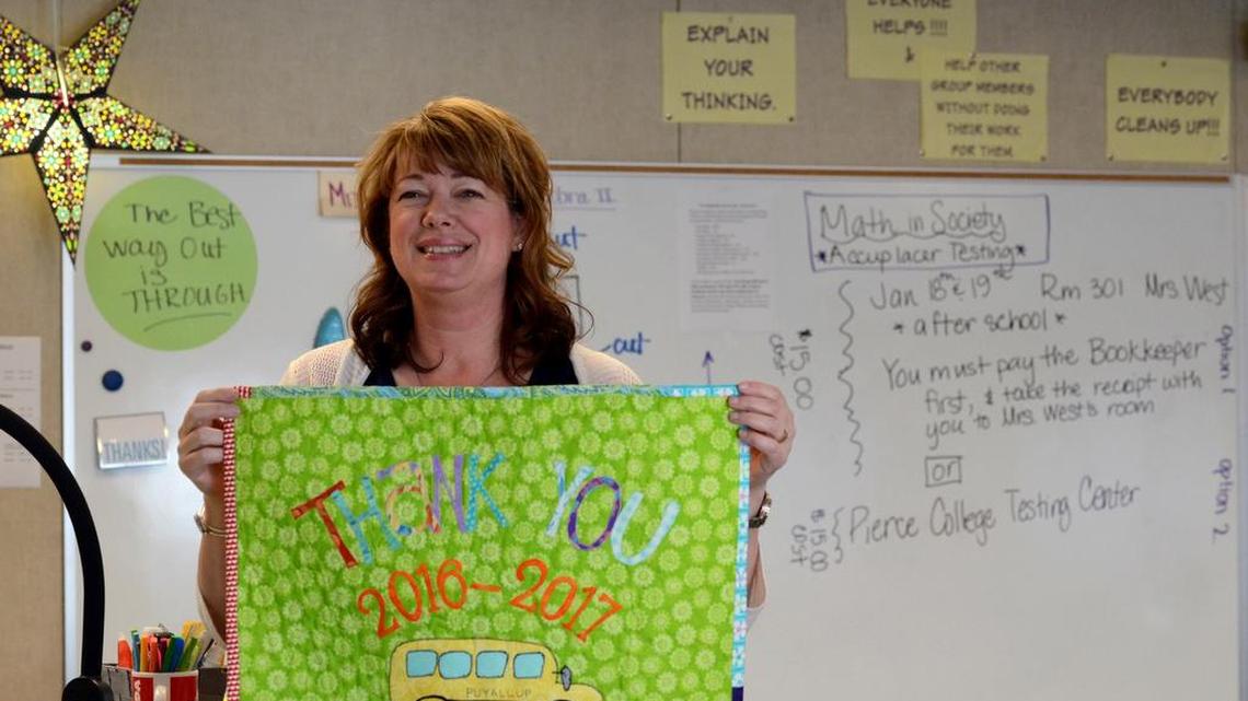 Puyallup High math teacher Leigh Ann Mahaffie holds up a thank-you quilt she made.