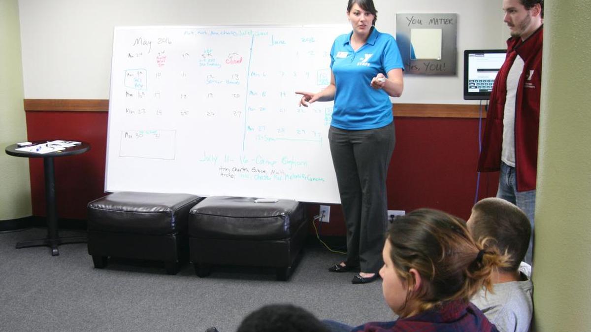 Youth Investment Center program director Renne Gilliam goes over the upcoming schedule of events with a group of teens last week at the center in downtown Puyallup.