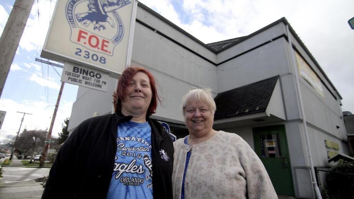 Puyallup Eagles Daffodil Aerie 2308 manager Loni Anderews, left, and secretary Ellen Blakely stand in front of the main entrance to their club. Sound Transit is negotiating with the Eagles to buy the structure to expand its footprint in downtown Puyallup.