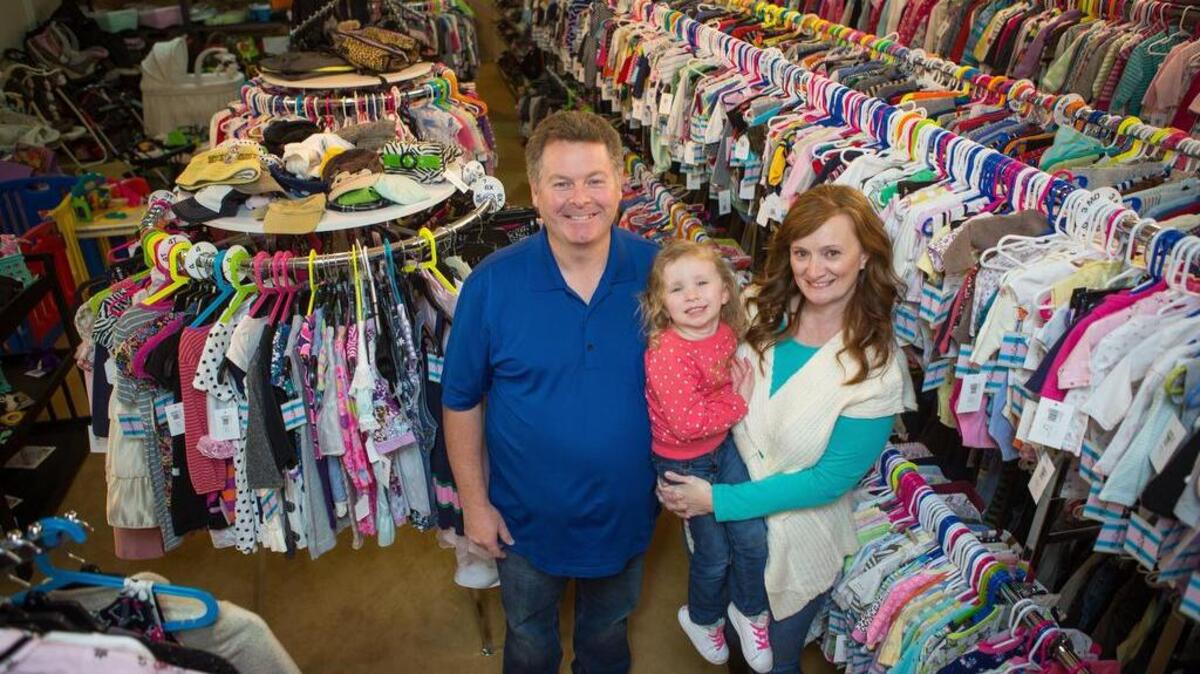 Del and Jennifer Briley stand for a portrait with their granddaughter, Rhys, inside Weecycled, their baby retail and consignment shop in downtown Puyallup.