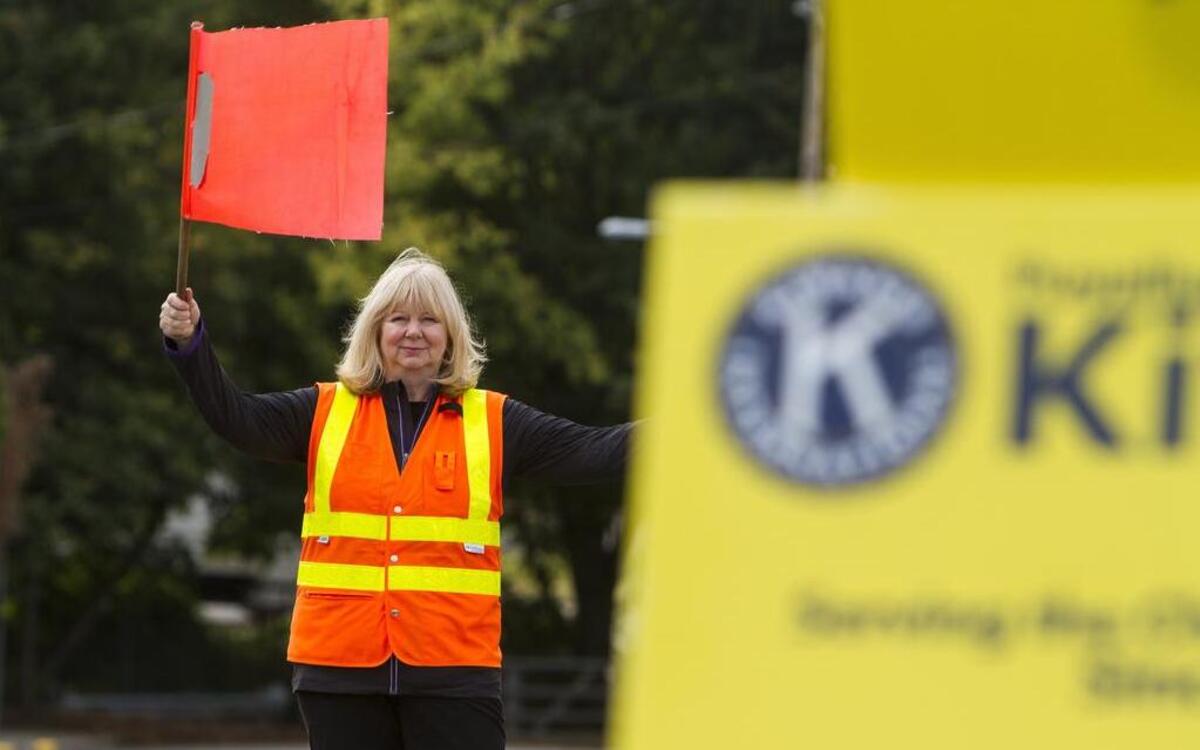 Heidi Schuler flags down cars to park at the Kiwanis lot in Puyallup. The club is partnering with Life Care Center of Puyallup to use its land to charge for parking at the Washington State Fair.
