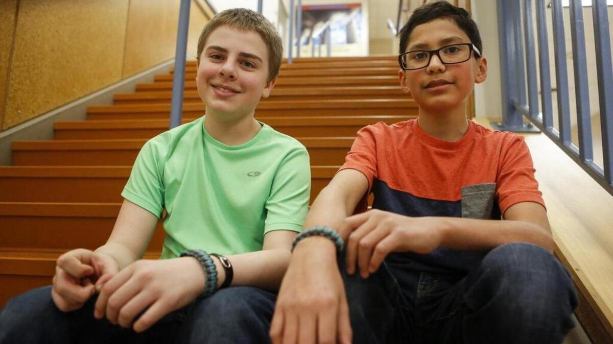 Edgerton Elementary sixth-graders Connor McKenna, left, and Spencer Hensley sit for a portrait at the school in Puyallup last week. When Spencer discovered Connor has Postural orthostatic tachycardia syndrome, which causes him to pass out intermittently, Spencer began selling bracelets in an effort to raise money to purchase a service dog of McKenna.