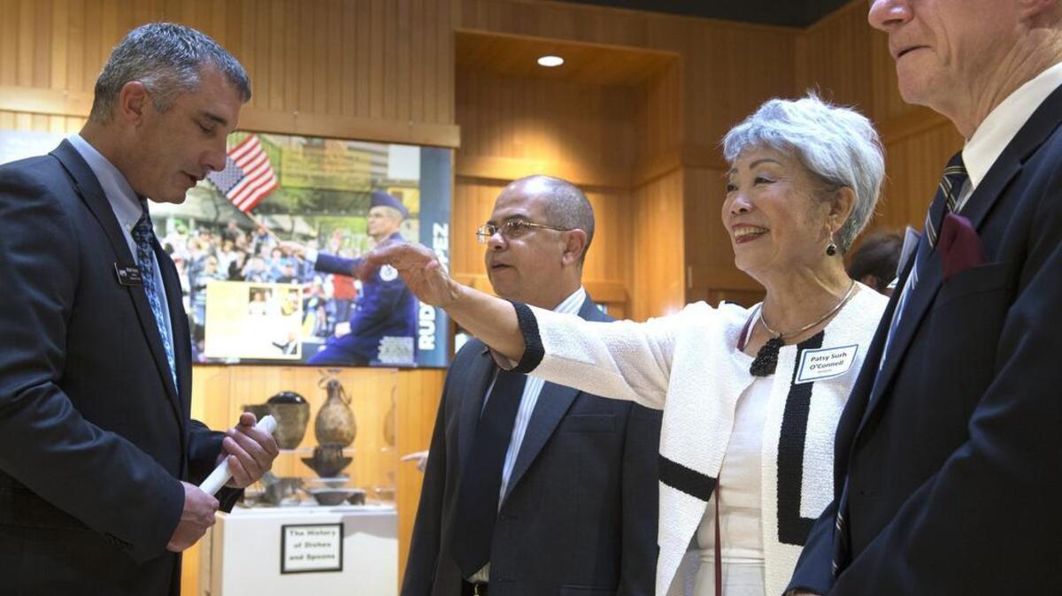 Honorees Patsy Surh O’Connell, waving, and Rudy Lopez, center, talk with assistant Secretary of State Mark Neary, left, and John Hughes during an open house to welcome the “Who Are We?” exhibit from the Office of the Secretary of State at the Karcher Museum and Center for Arts & Culture in Puyallup on Wednesday, Aug. 23. O’Connell is the founder of the Asia Pacific Cultural Center in Tacoma. Lopez is the director of the Washington State Veterans Cemetery in Spokane.