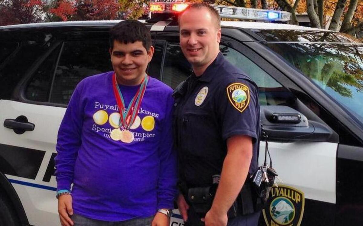 Puyallup police patrol officer Shaun Nestor stands with a Puyallup Special Olympian at last year’s Tip a Cop fundraiser for local Special Olympians.