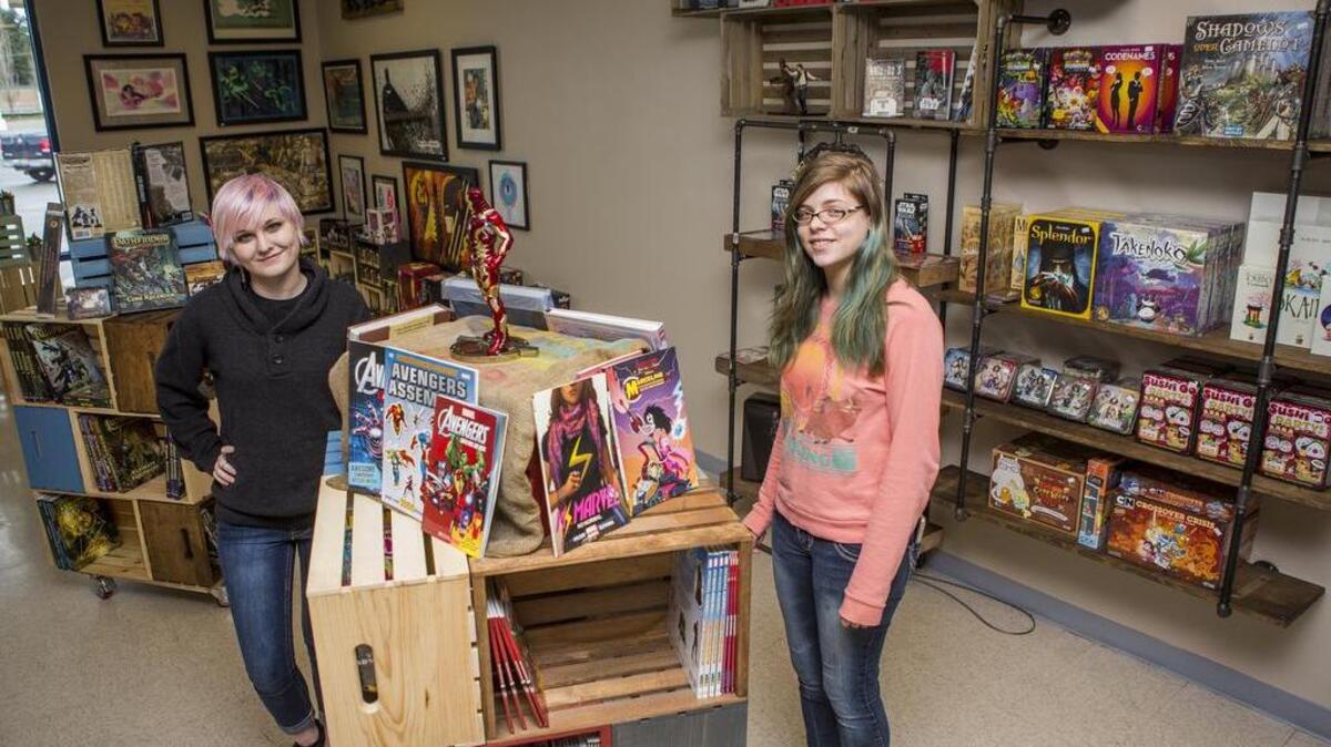 Employees Brittany Church, left, and Kelsey Arnum gather in the main showroom at South Hill Games and More last week. The store sells games, comics, and collectibles and features a gaming space.
