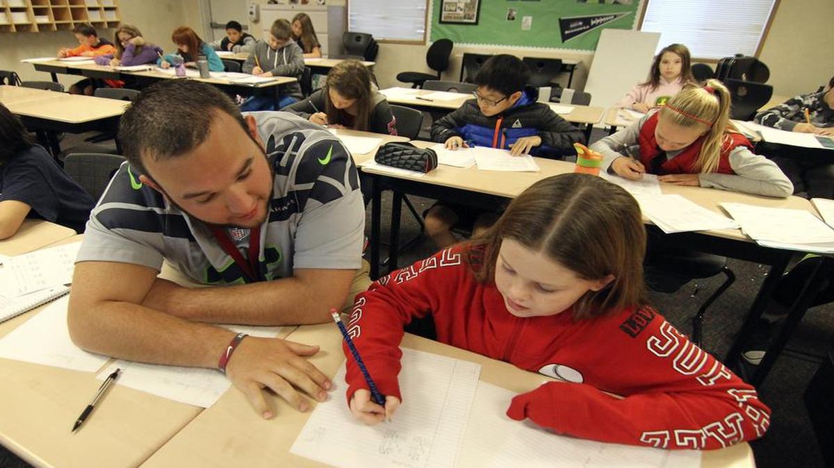 
Ballou Junior High School math teacher Troy Meacham works with Mia Bragg, 11, one of his sixth-grade students during math studies last week. The school has accepted overflow students from nearby overcrowded schools and housed them in portable classrooms.
