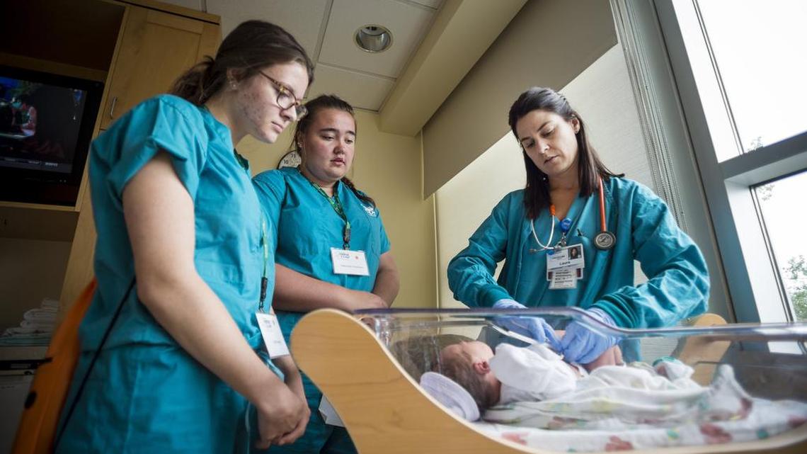 Nurse Camp students Faith Smyth, left, and Gabrielle Timmons, center, watch as registered nurse Laura Headley cuts the umbilical cord of a baby at Good Samaritan Hospital in Puyallup on July 20.