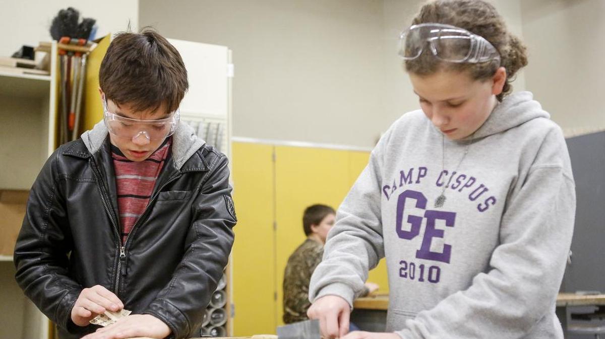 Frederick Smith, left, and Anna Donnelly sand their key holder projects in Paul Martin’s wood shop class at Ferrucci Junior High School in Puyallup.